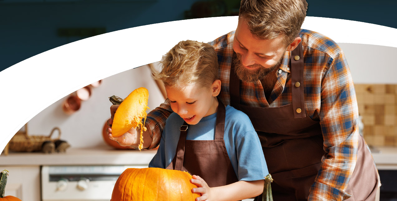 Dad carving pumpkins with son